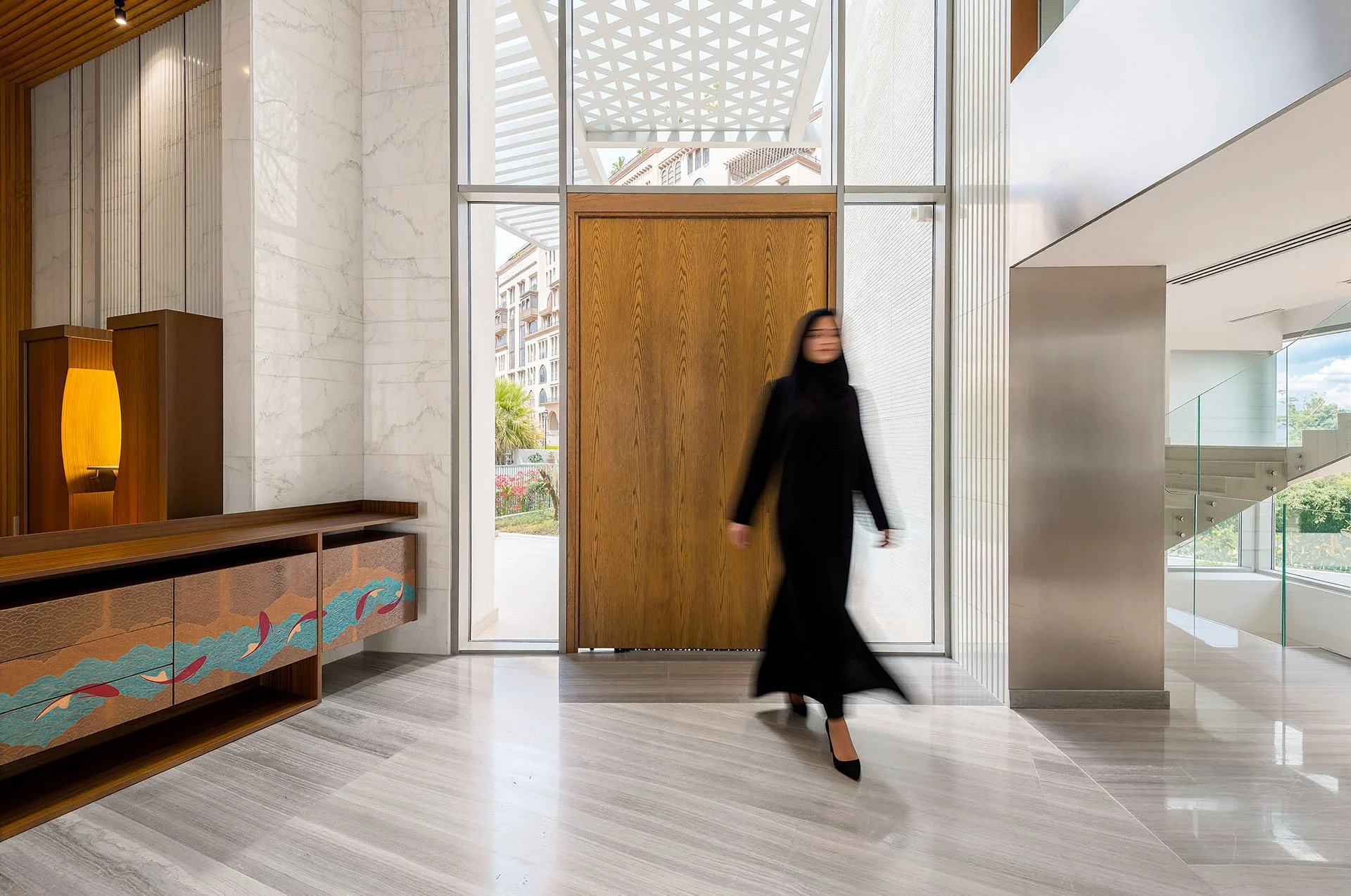 Double height grand entrance hall with floor to ceiling glass windows and marble floors at luxury residence in Doha by Hammad Iqbal