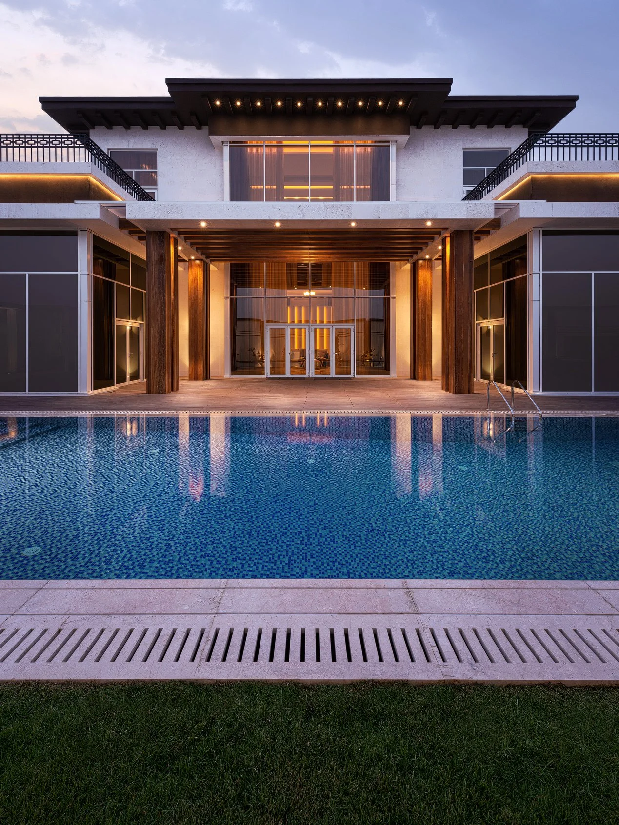 Symmetrical twilight exterior photo of a luxury villa rear facade reflected in a large swimming pool in West Wukair Qatar by Hammad Iqbal