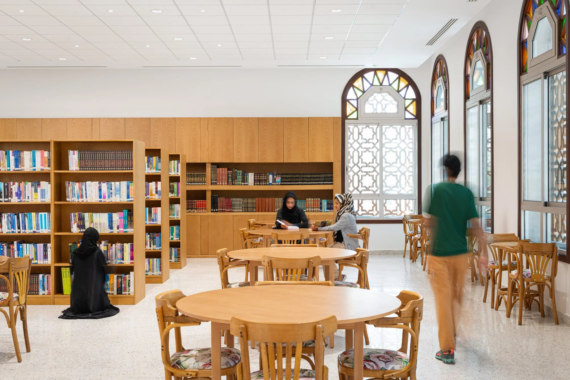 Main reading hall at Dar Al Kutub featuring traditional Qatari arched windows and custom wooden shelving photographed by architectural photographer Hammad Iqbal