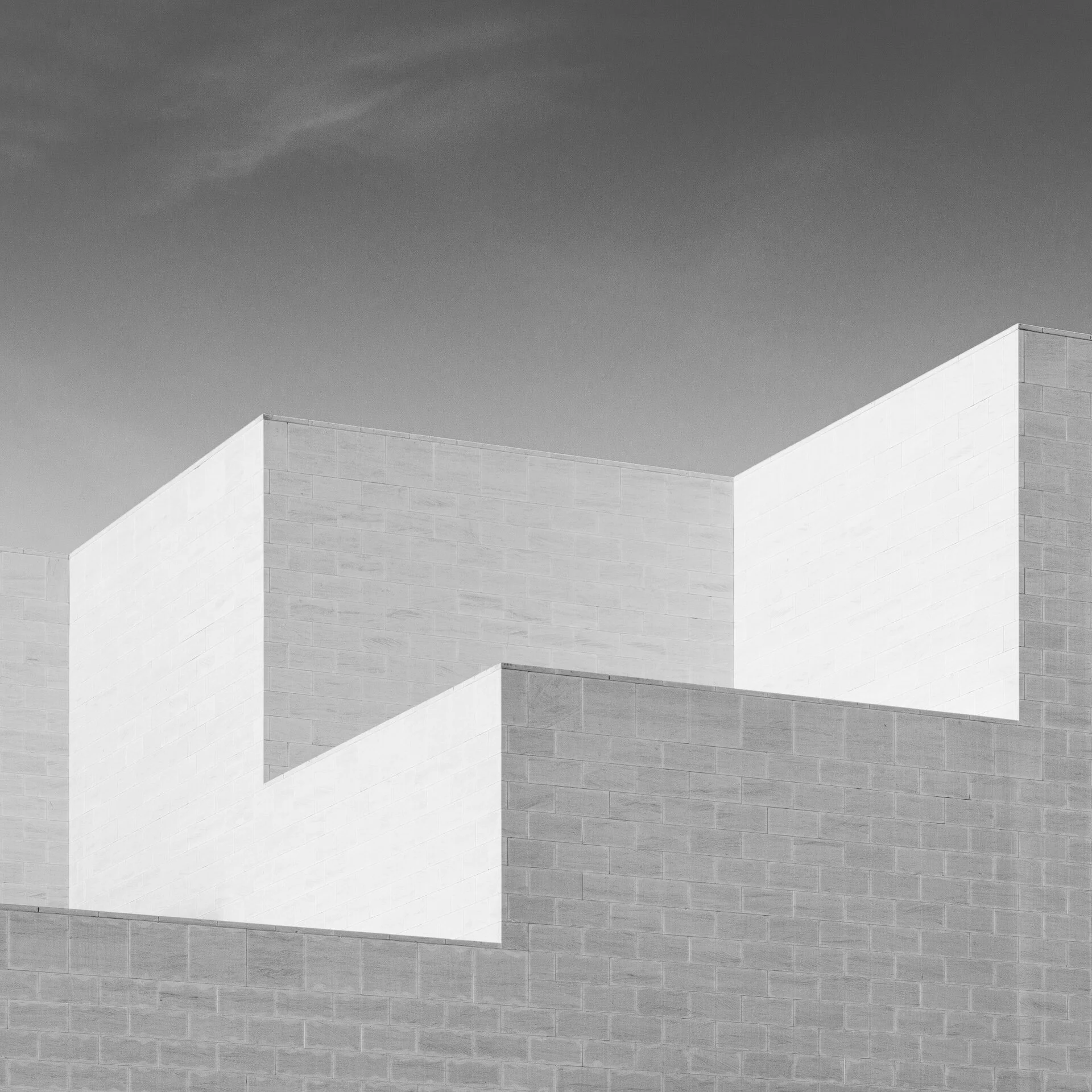 Minimalist black and white abstract details of intersecting cubic limestone walls at the Museum of Islamic Art photographed by Hammad Iqbal in Doha