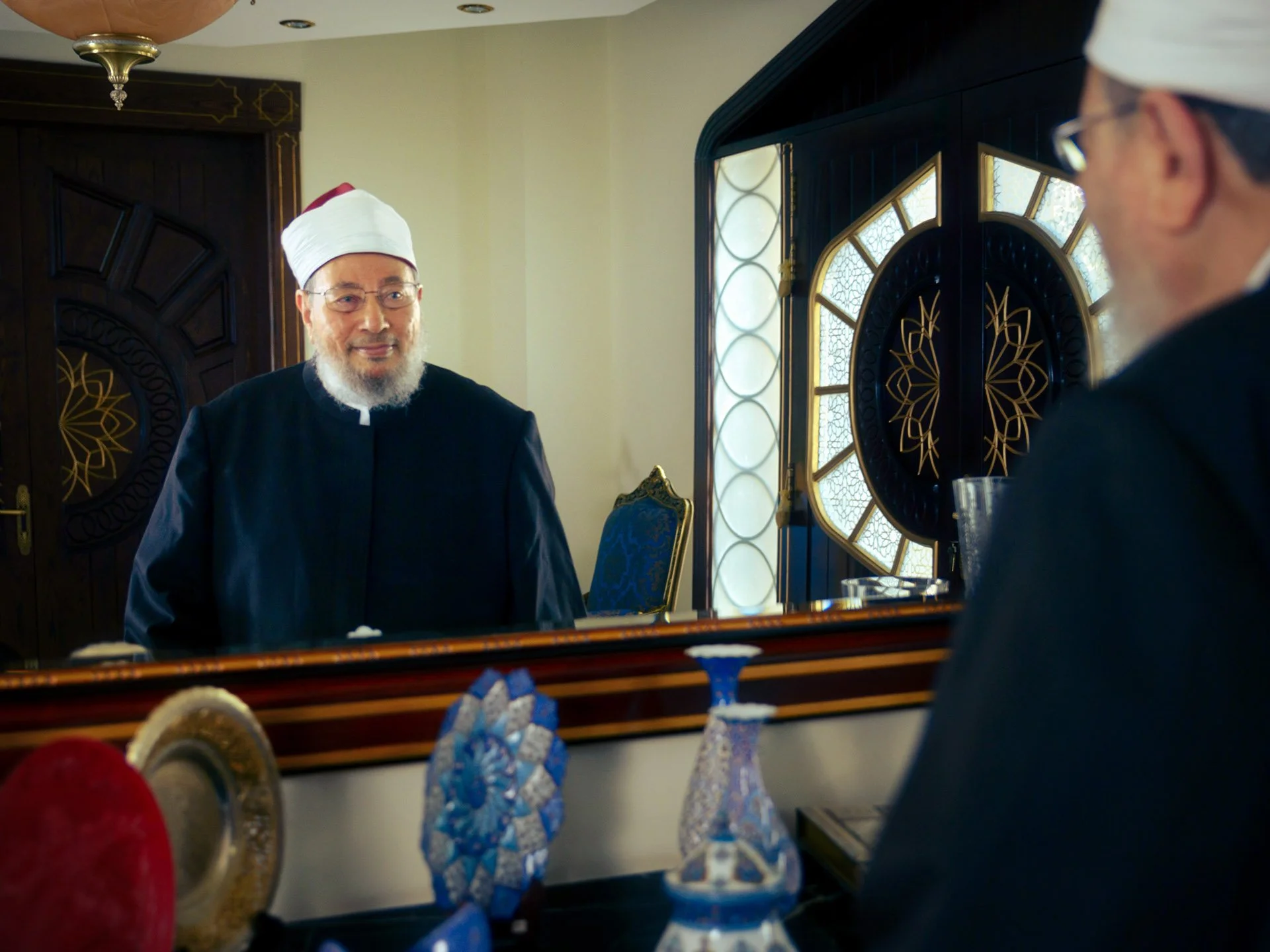 Creative mirror reflection portrait of Sheikh Yusuf Al-Qaradawi wearing a white and red turban cap in Doha by Hammad Iqbal