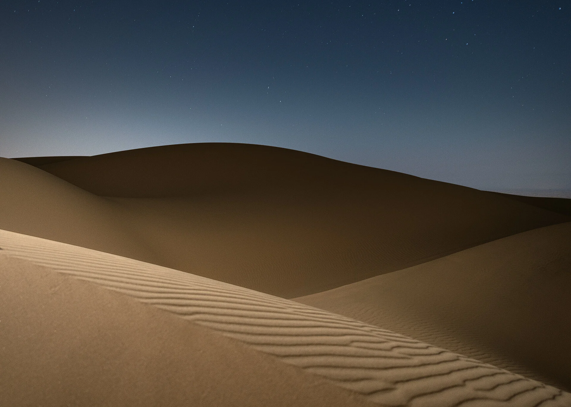 Low angle night photograph of a sand dune valley highlighted by off-camera flash in Qatar by Hammad Iqbal