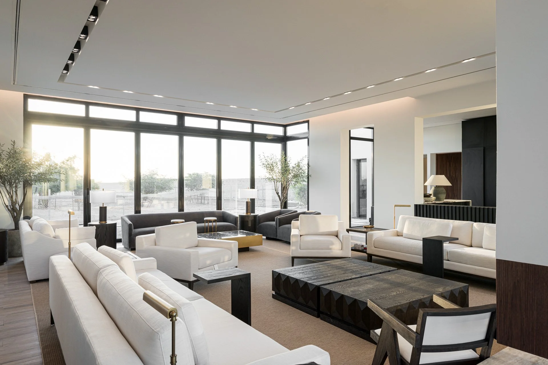 Deep perspective interior photograph of open plan luxury lounge with cream sofas and black coffee tables by Hammad Iqbal