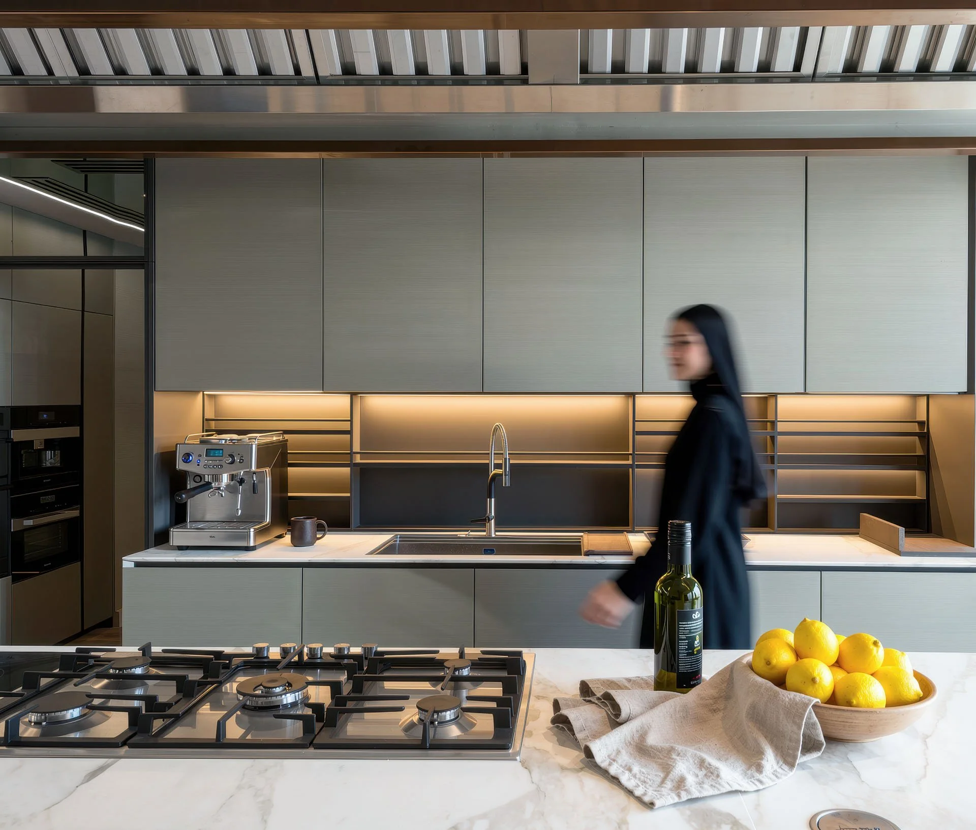 Contemporary dark executive kitchen with gas cooktop and marble waterfall counter in luxury villa by Hammad Iqbal