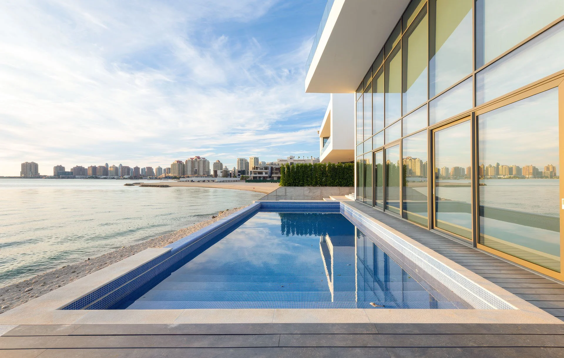 Daytime landscape photo of private infinity pool overlooking the gulf beach at luxury villa in The Pearl Qatar by Hammad Iqbal
