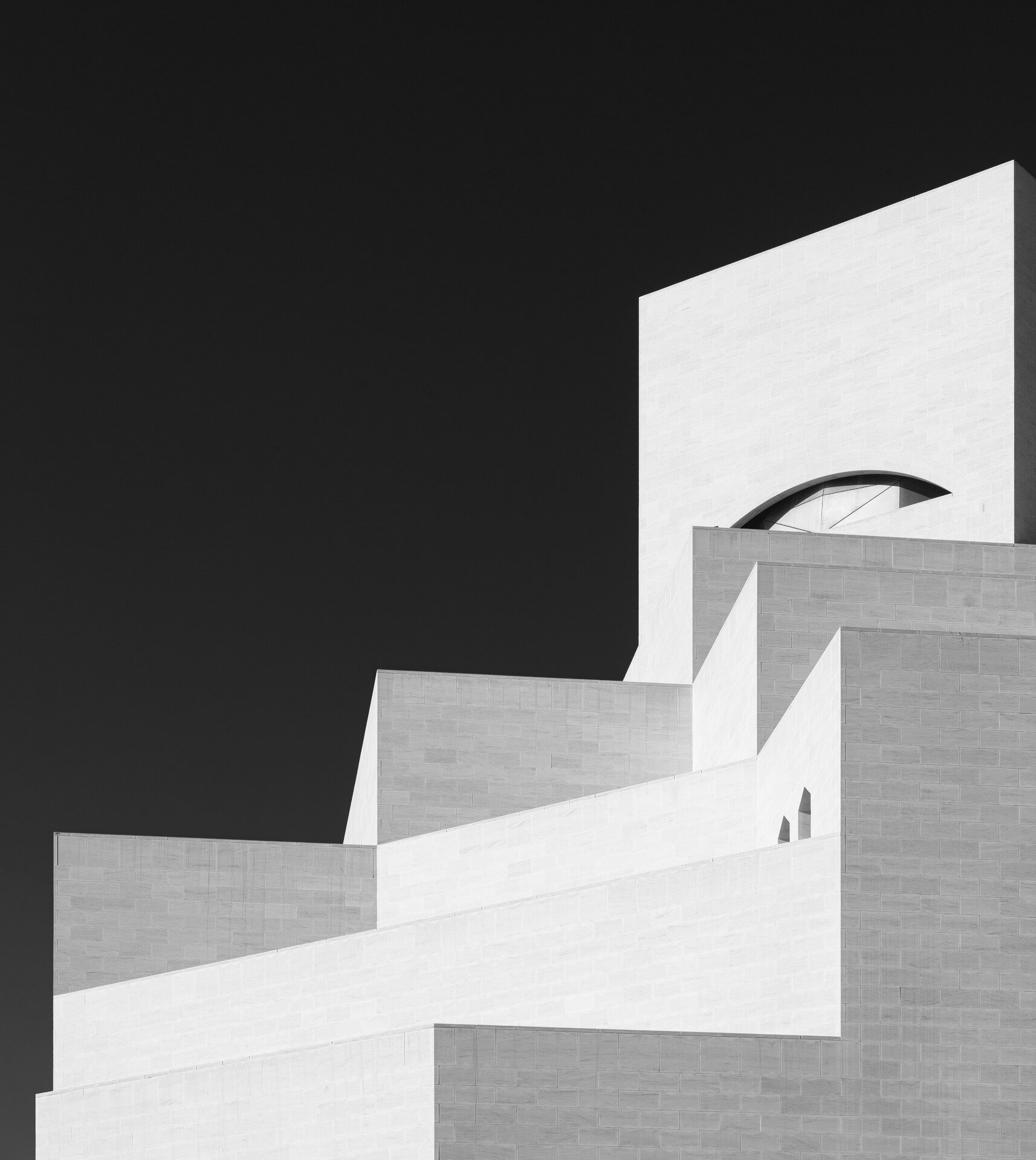 High contrast black and white abstract shot of the geometric limestone tiers of the Museum of Islamic Art in Doha by architectural photographer Hammad Iqbal