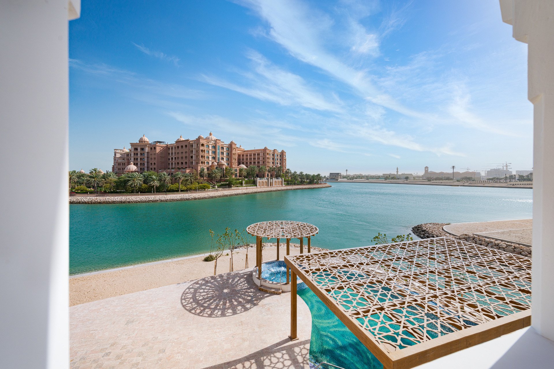 High angle daytime photo of a private beach gazebo and timber pergola overlooking Marsa Malaz Kempinski in The Pearl Qatar photographed by Hammad Iqbal
