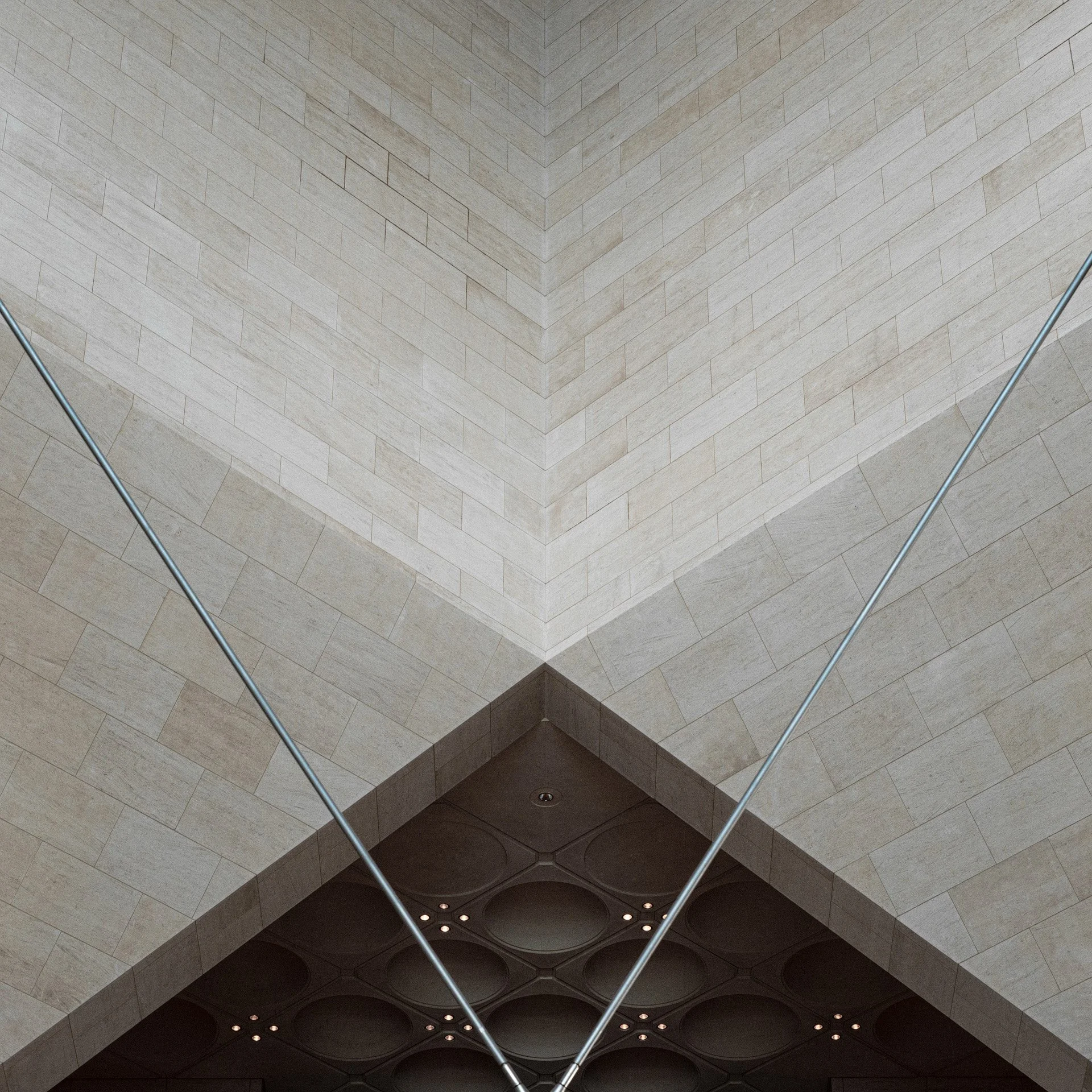 Symmetrical low-angle photograph of the interior central atrium ceiling and tension cables at the Museum of Islamic Art in Doha by Hammad Iqbal