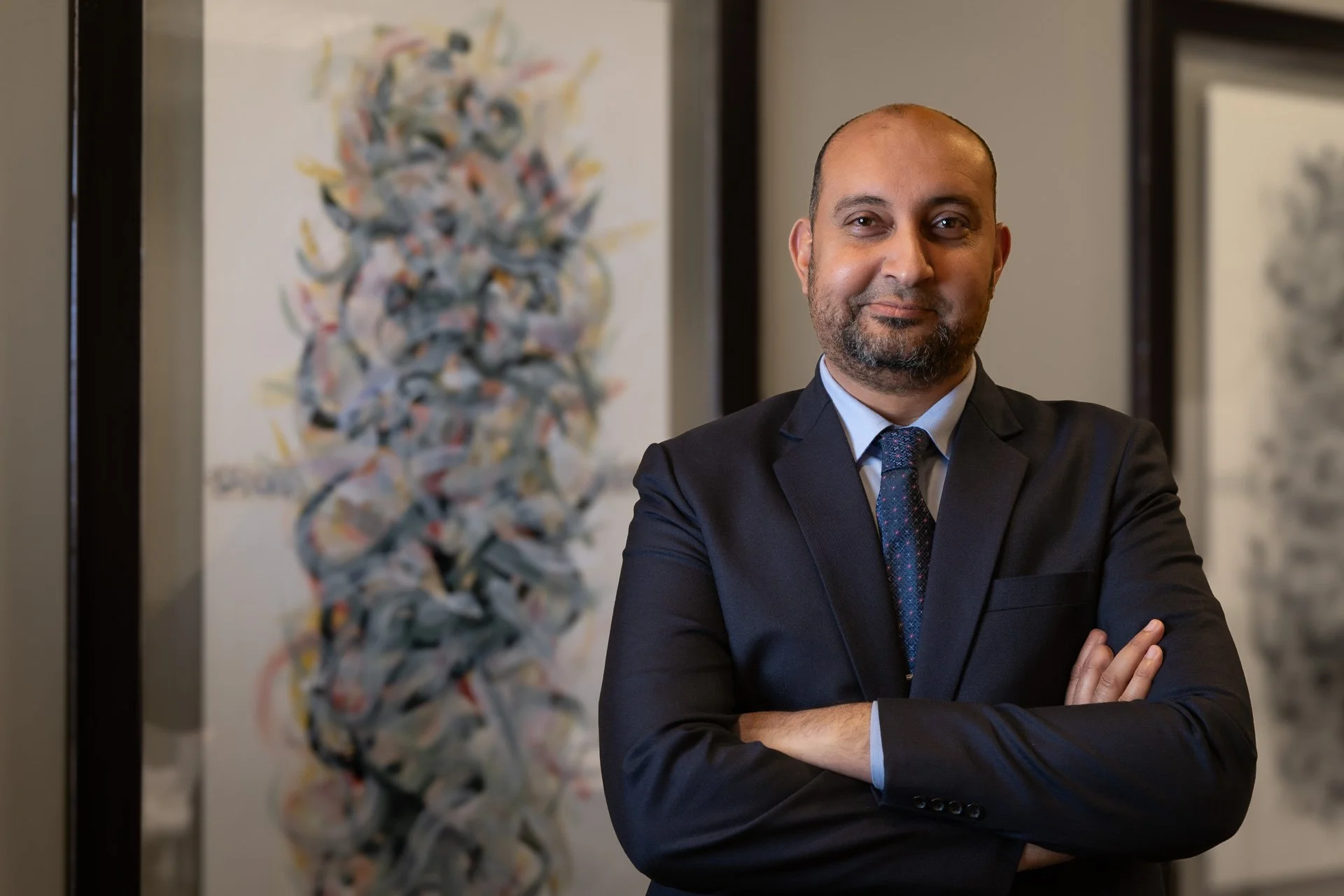 Professional executive portrait of a smiling senior advocate in a suit at Abdullah Al-Mulla Law Firm by Hammad Iqbal