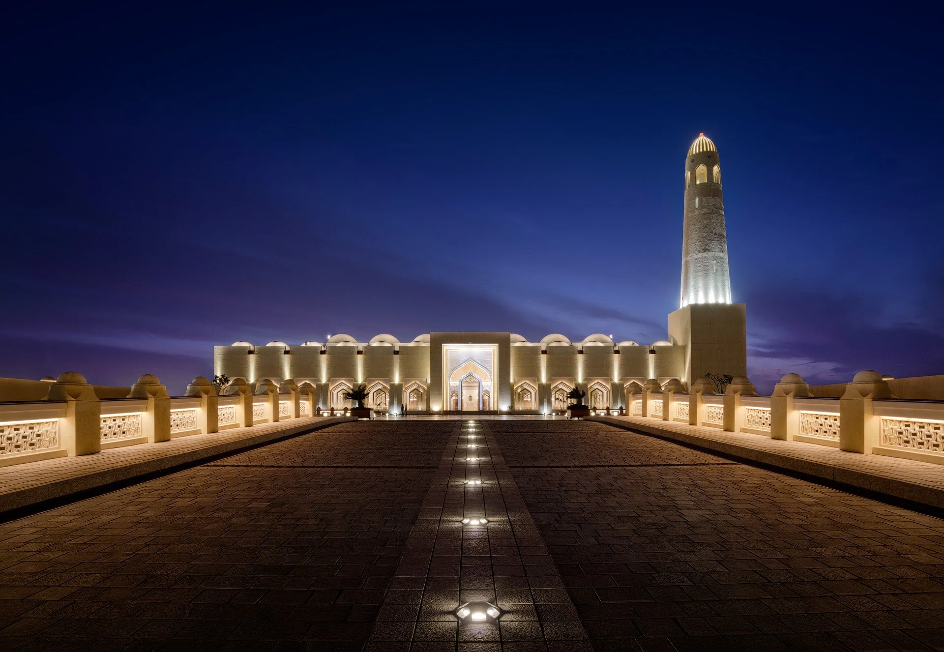 Symmetrical blue hour photo of the illuminated exterior courtyard and minaret at Imam Muhammad bin Abdul Wahhab Mosque in Doha Qatar by Hammad Iqbal