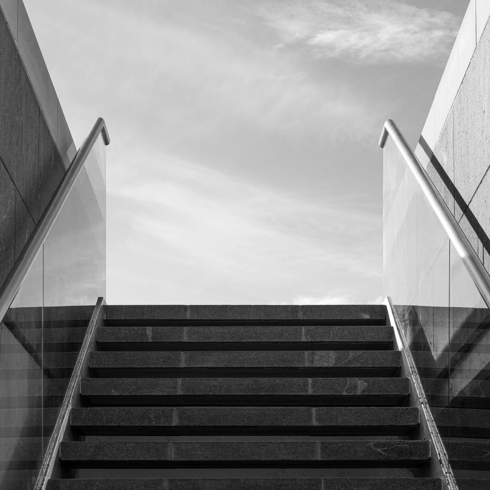 Monochrome low angle view looking up exterior granite stairs with glass handrails at the Museum of Islamic Art in Doha shot by Hammad Iqbal