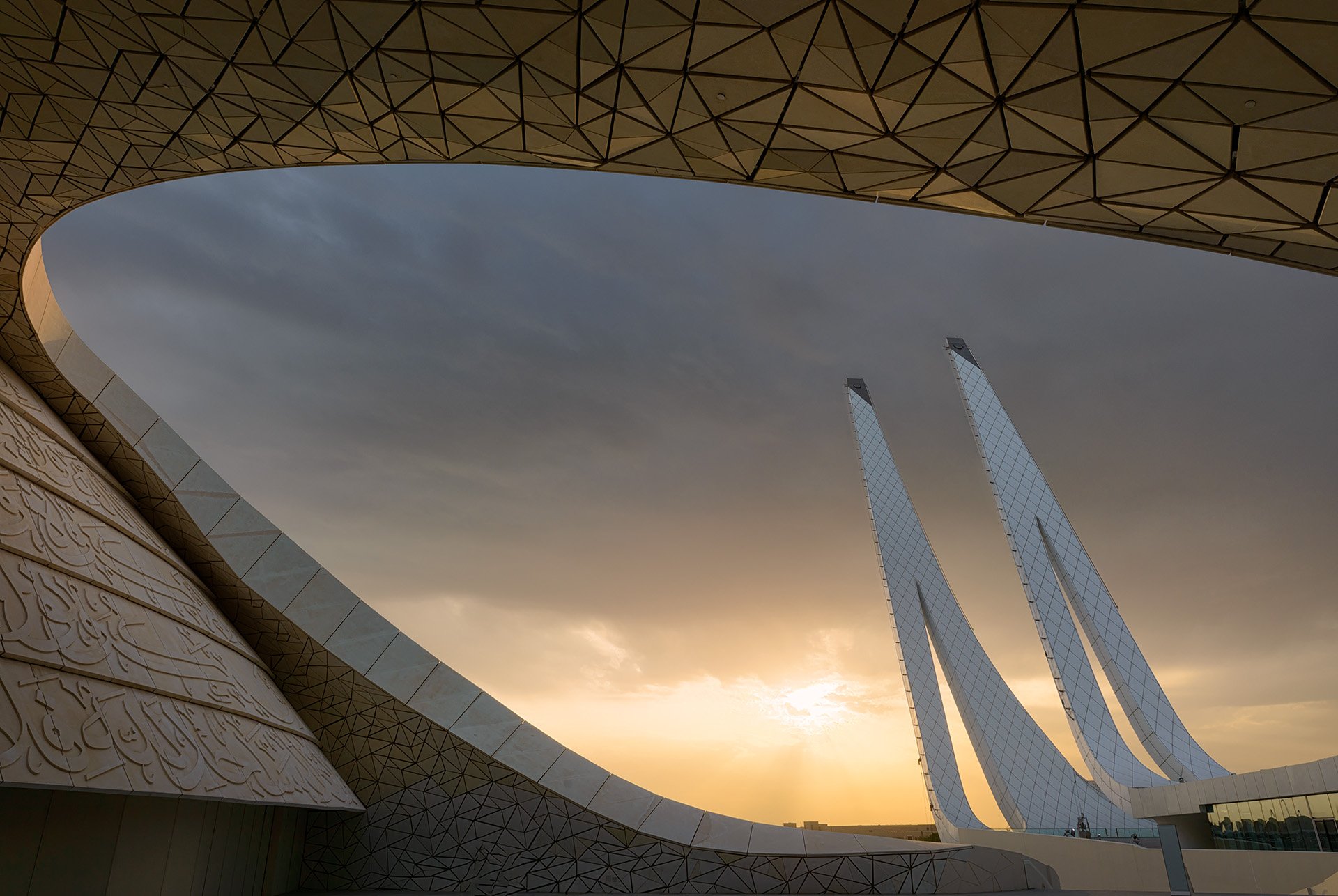 Golden hour at the Minaretein Center, featuring the interplay between golden dusk light, parametric geometric roof forms, and the iconic twin minarets of Education City.
