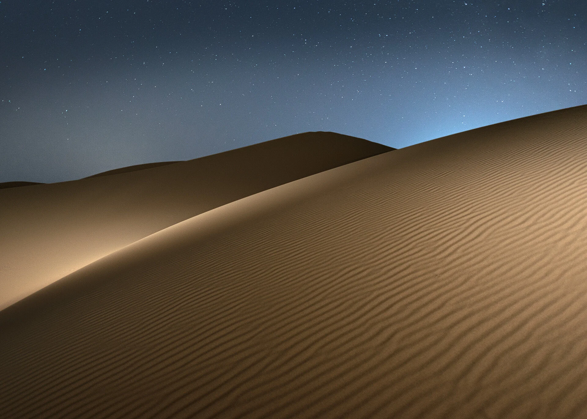 Side lit sand dune ripples sweeping across the desert frame at night in Qatar by Hammad Iqbal