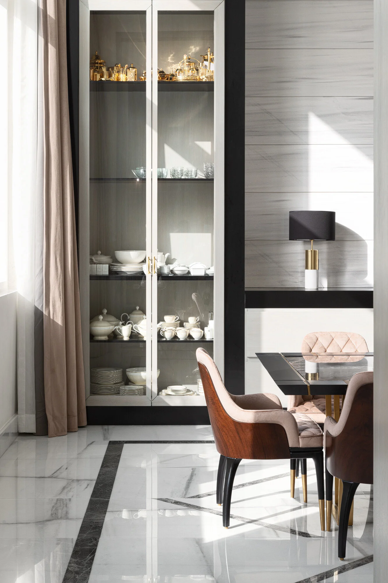 Contemporary formal dining room featuring illuminated glass china display cabinet marble flooring and velvet dining chairs in a West Wukair estate by Hammad Iqbal
