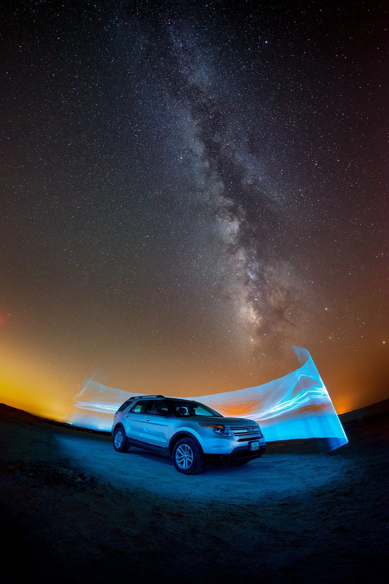 Creative cyan light painting ribbon wrapped around a Ford SUV under starry night sky in Qatar by Hammad Iqbal