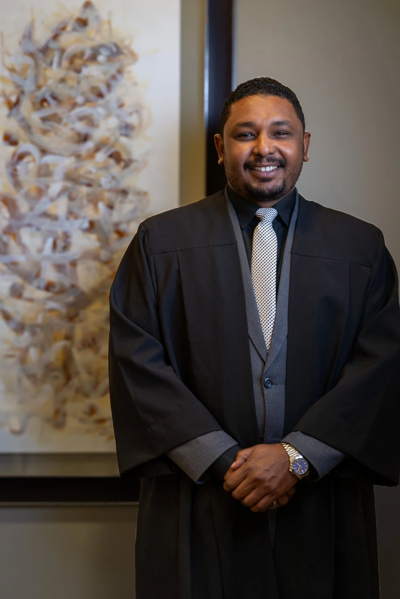 Corporate portrait of a male advocate wearing a black legal robe in a modern Doha office by Hammad Iqbal