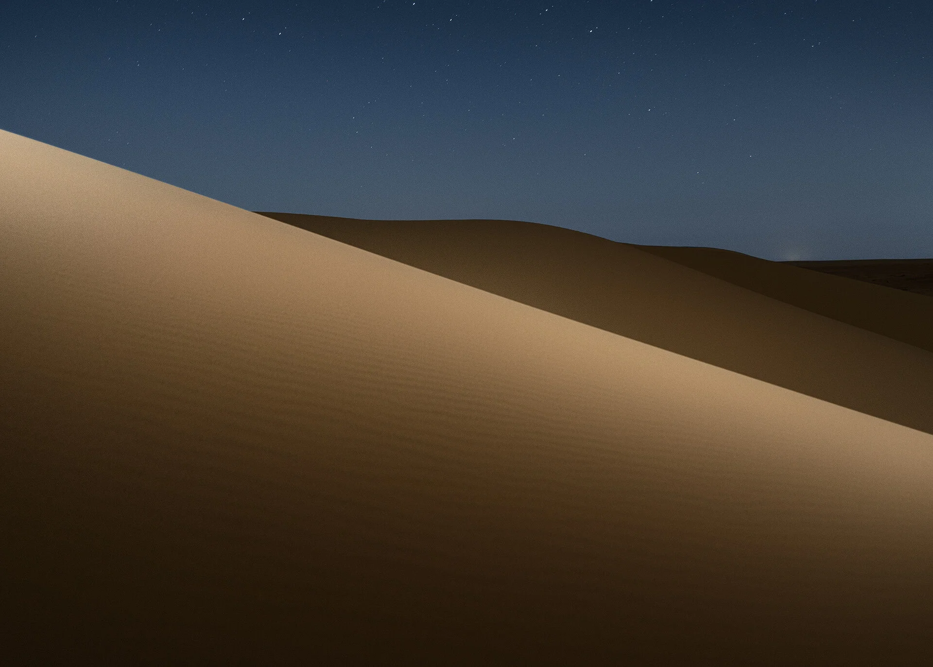Fine art landscape photo showing diagonal shadow line across a illuminated sand dune in Qatar by Hammad Iqbal