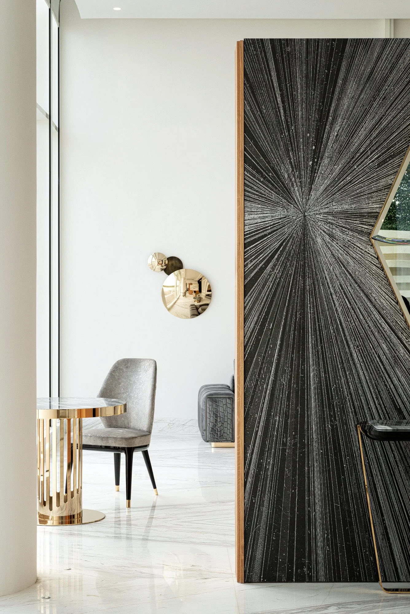 Interior architectural detail shot showing gold wall sconce custom textured feature wall and grey armchair photographed by Hammad Iqbal