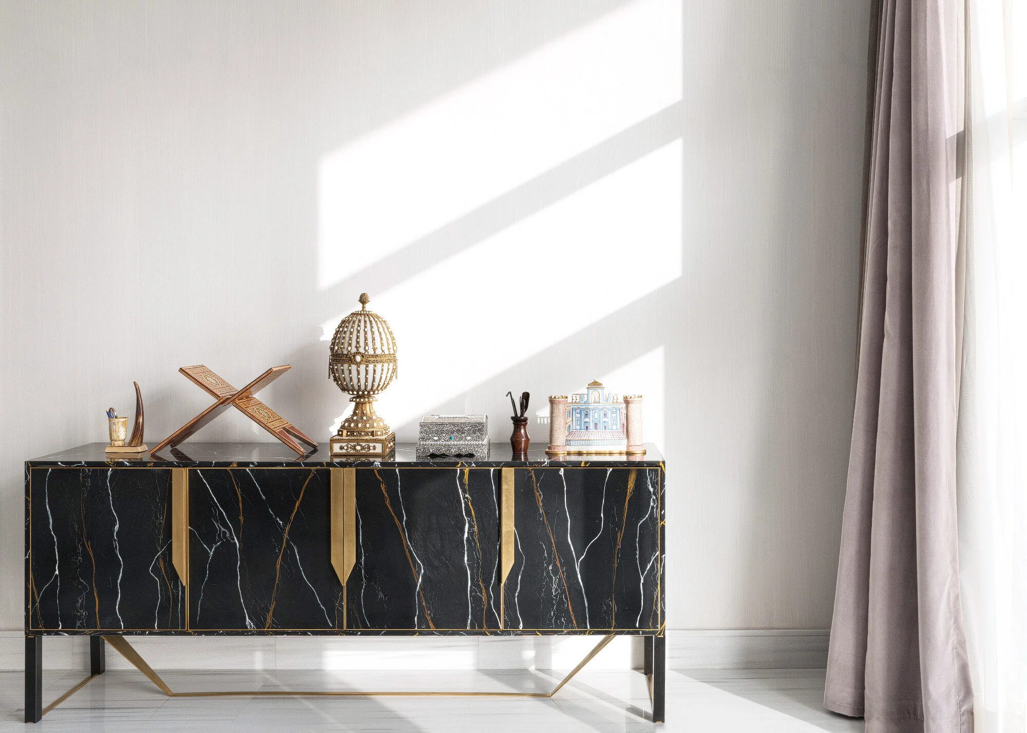 Interior vignette showing a gold veined black marble credenza console and floor length drapes bathed in natural light photographed by Hammad Iqbal
