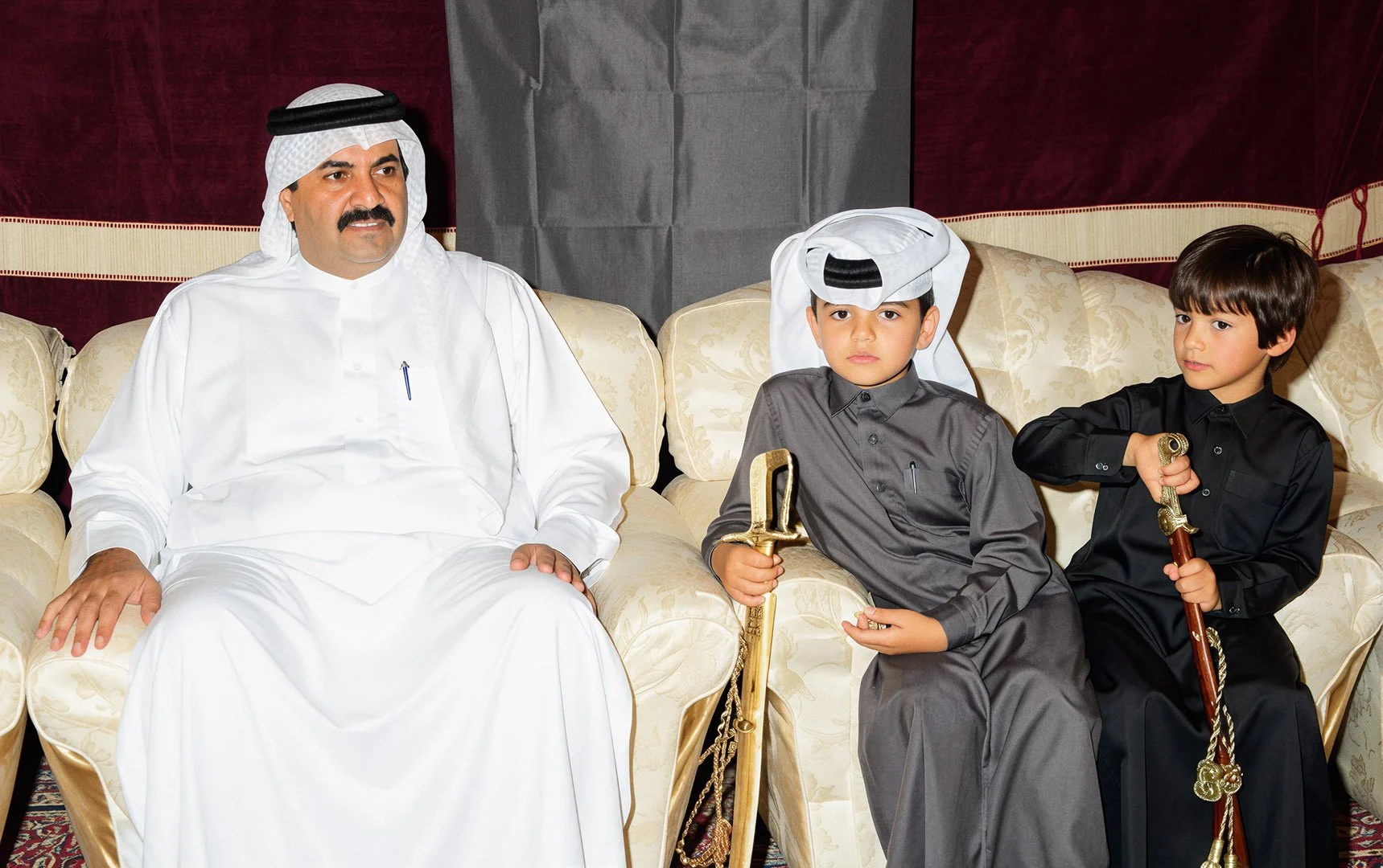  Reconstructed Image — His Highness Sheikh Hamad bin Khalifa Al Thani seated indoors with family. 