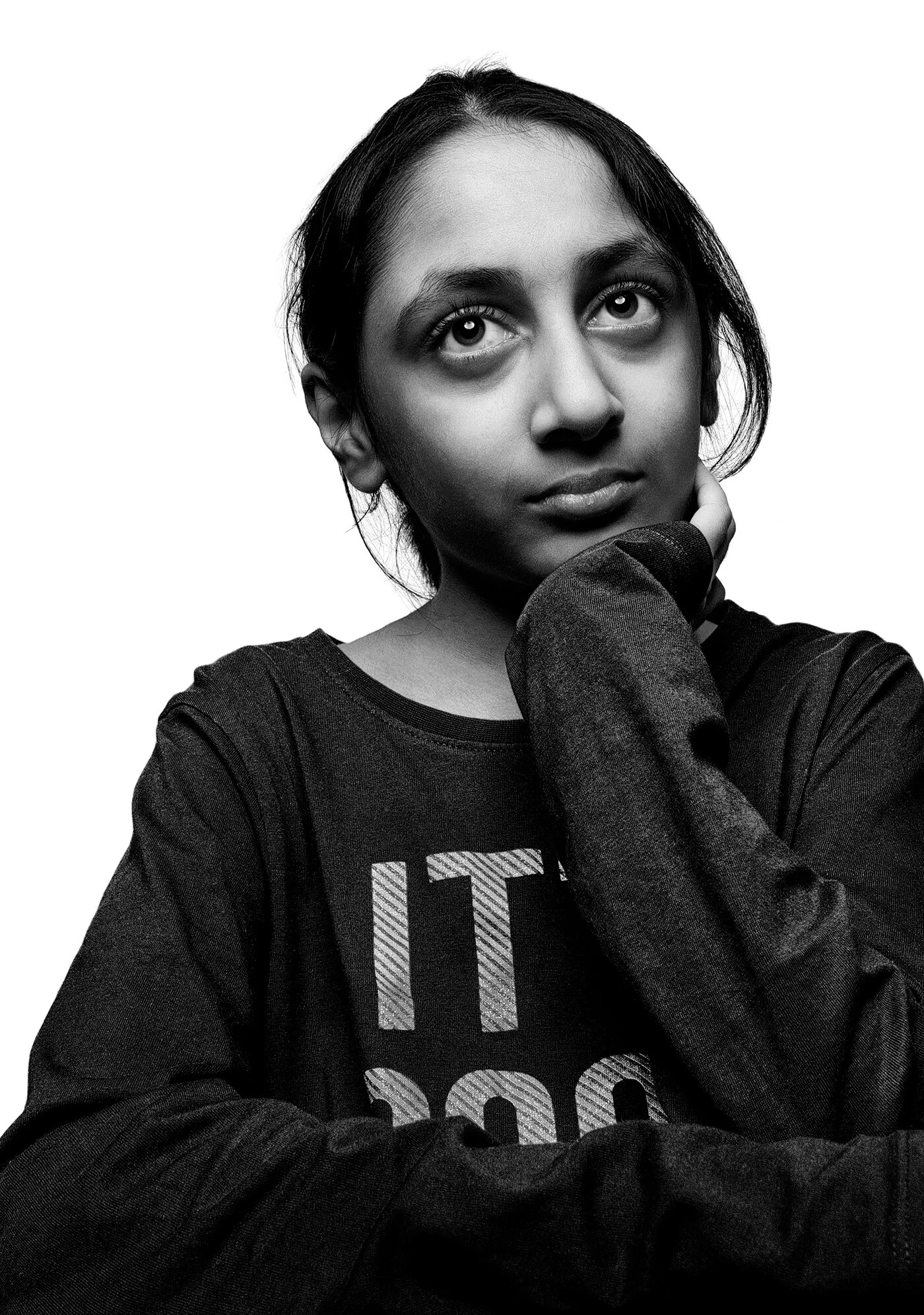 Pensive black and white portrait of young girl looking upward during quarantine by Hammad Iqbal