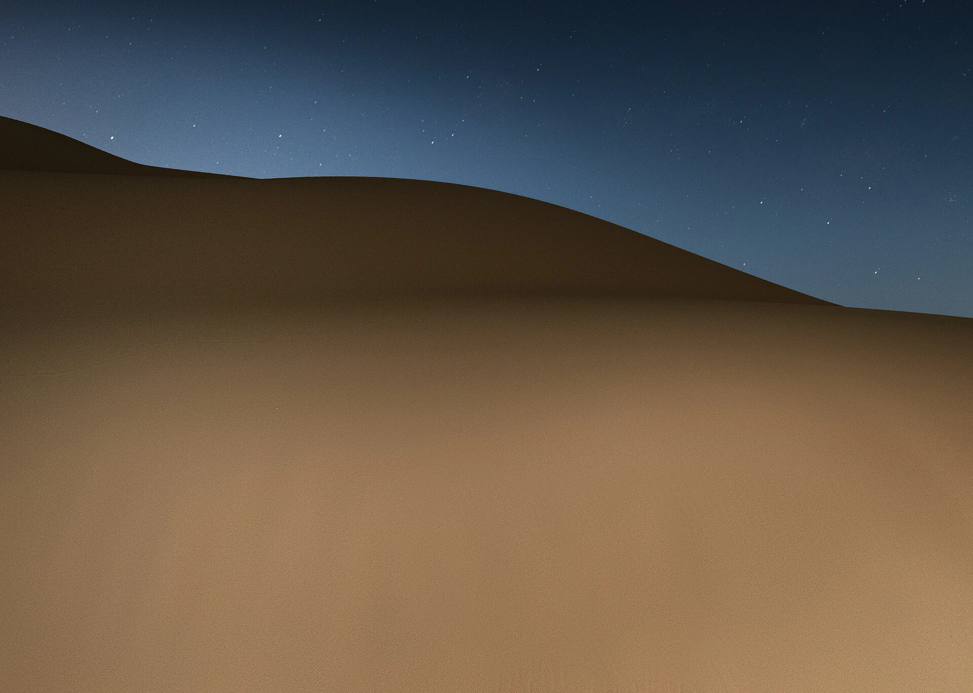 Minimalist night photograph of a softly lit sand dune slope in Qatar by Hammad Iqbal