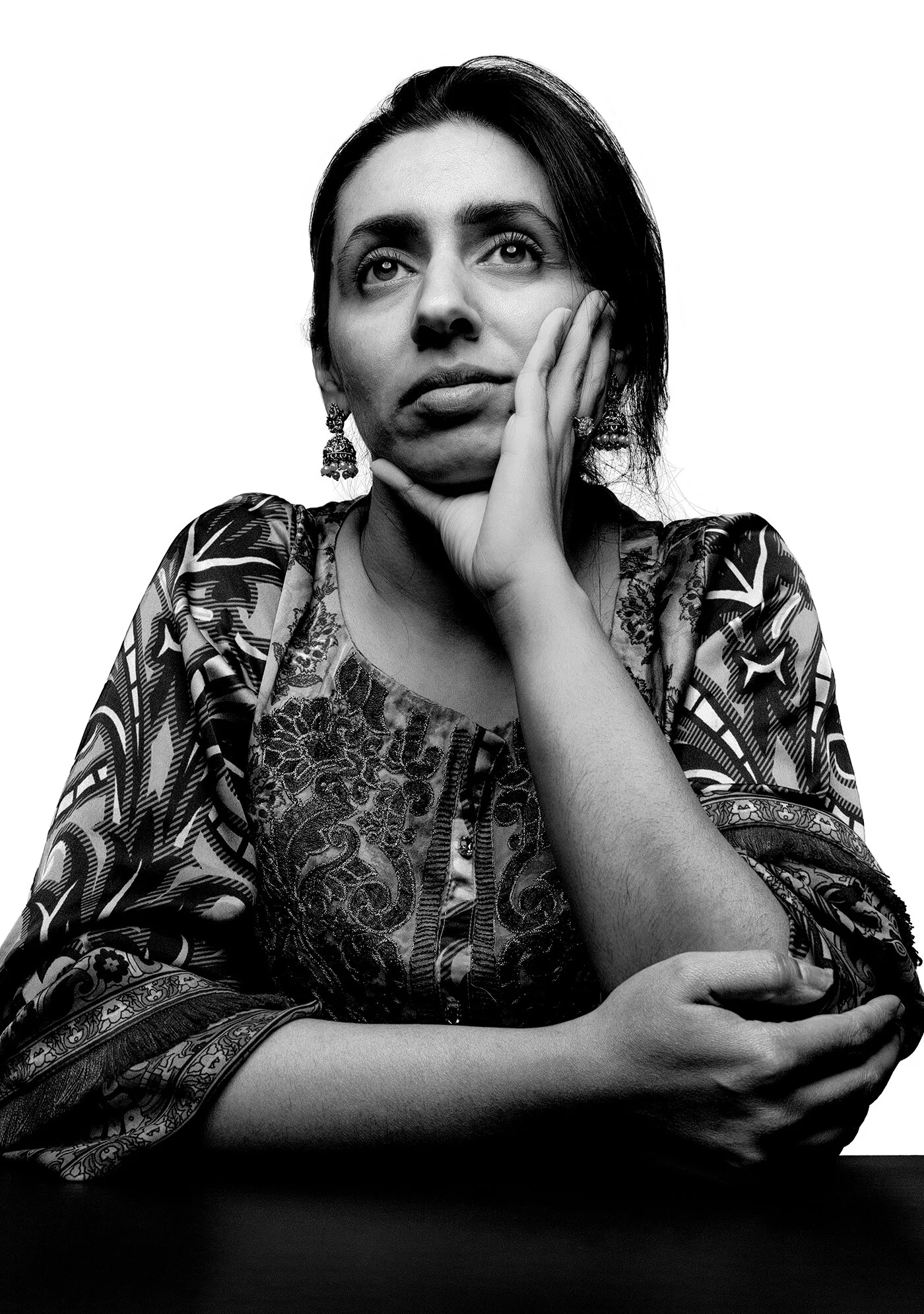 Thoughtful black and white portrait of woman leaning on hand during isolation by Hammad Iqbal