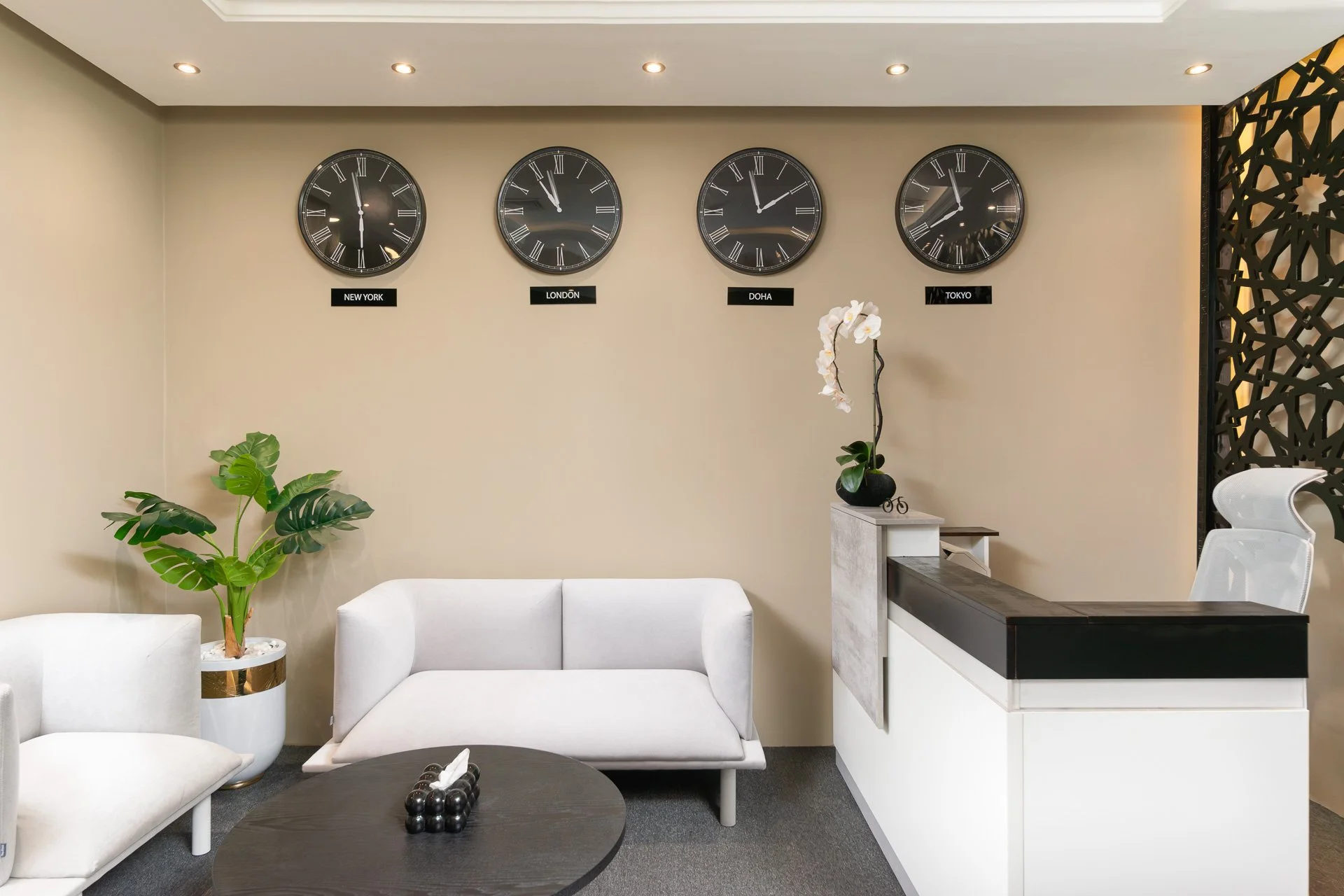 Clean interior shot of white leather sofa black coffee table and world clocks in a Doha law office reception by Hammad Iqbal