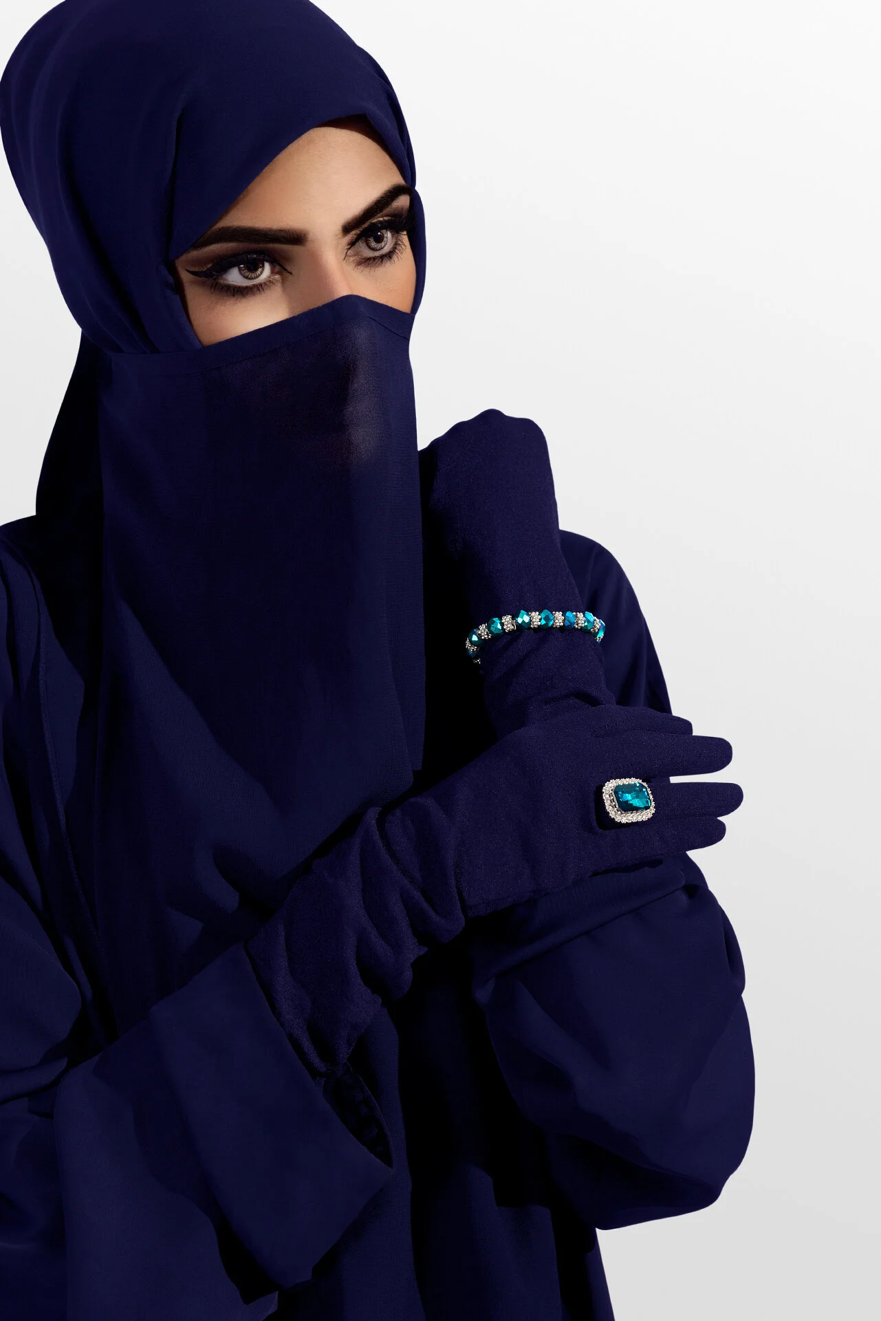 Close up portrait emphasizing eyes, dark gloves, and a silver turquoise ring in modest fashion styling by Hammad Iqbal
