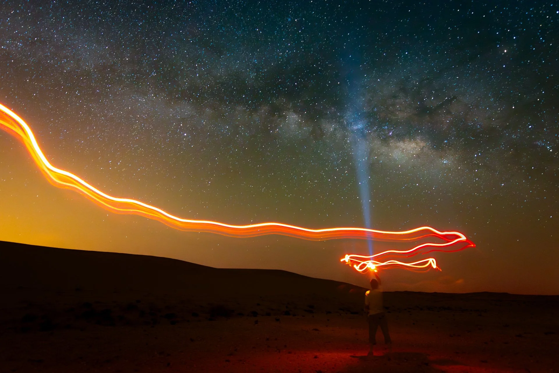 Creative light painting with red light trail and flashlight beam under the Milky Way in Qatar by Hammad Iqbal