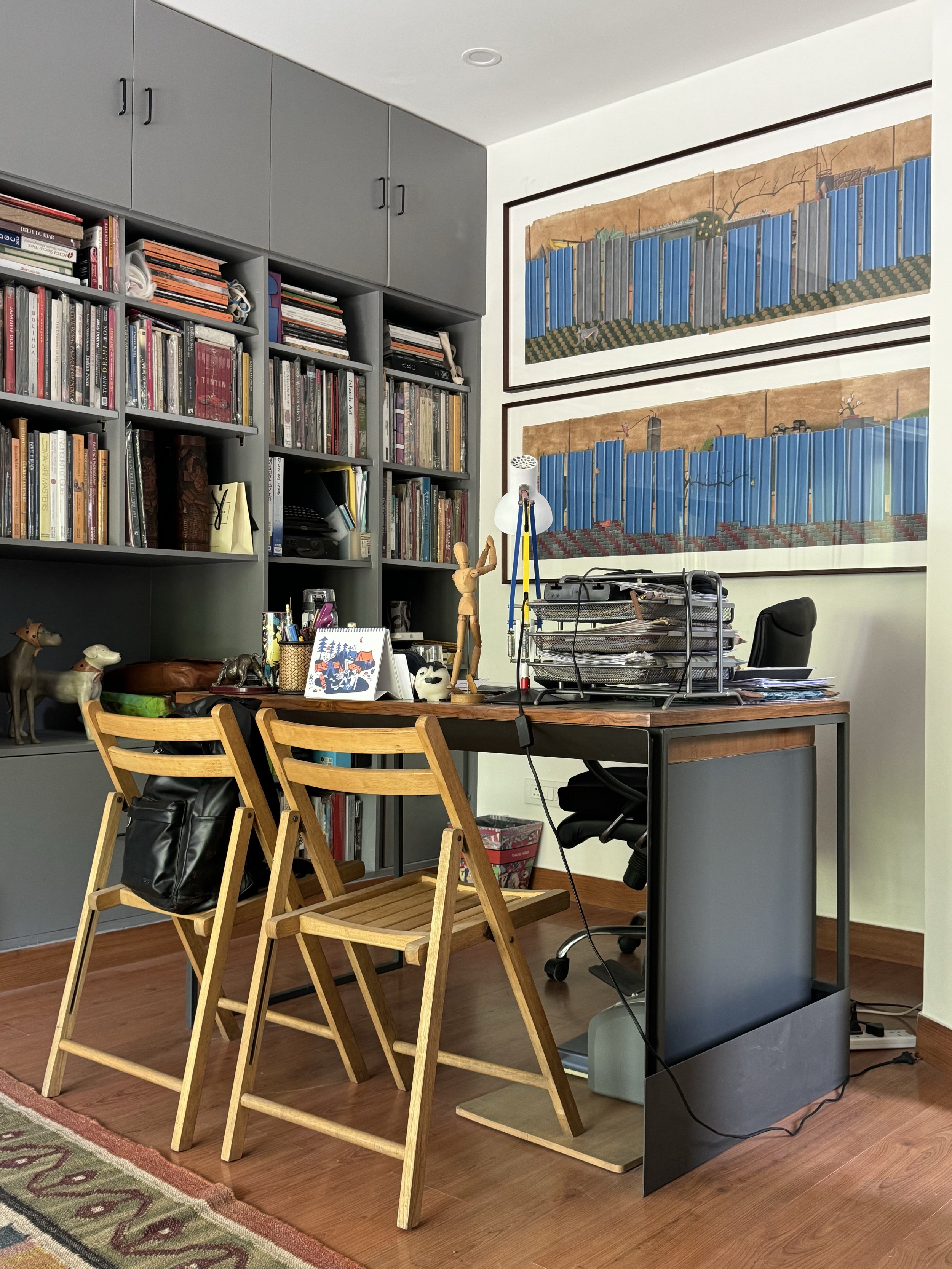 an office with two chairs and lots of books on a shelf