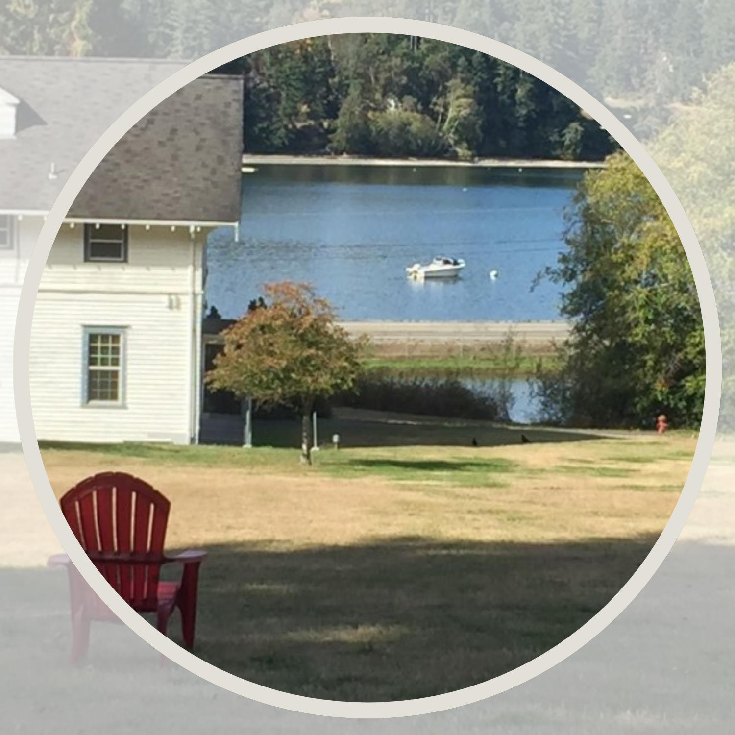 A white house, a red chair, a lake, and a meadow