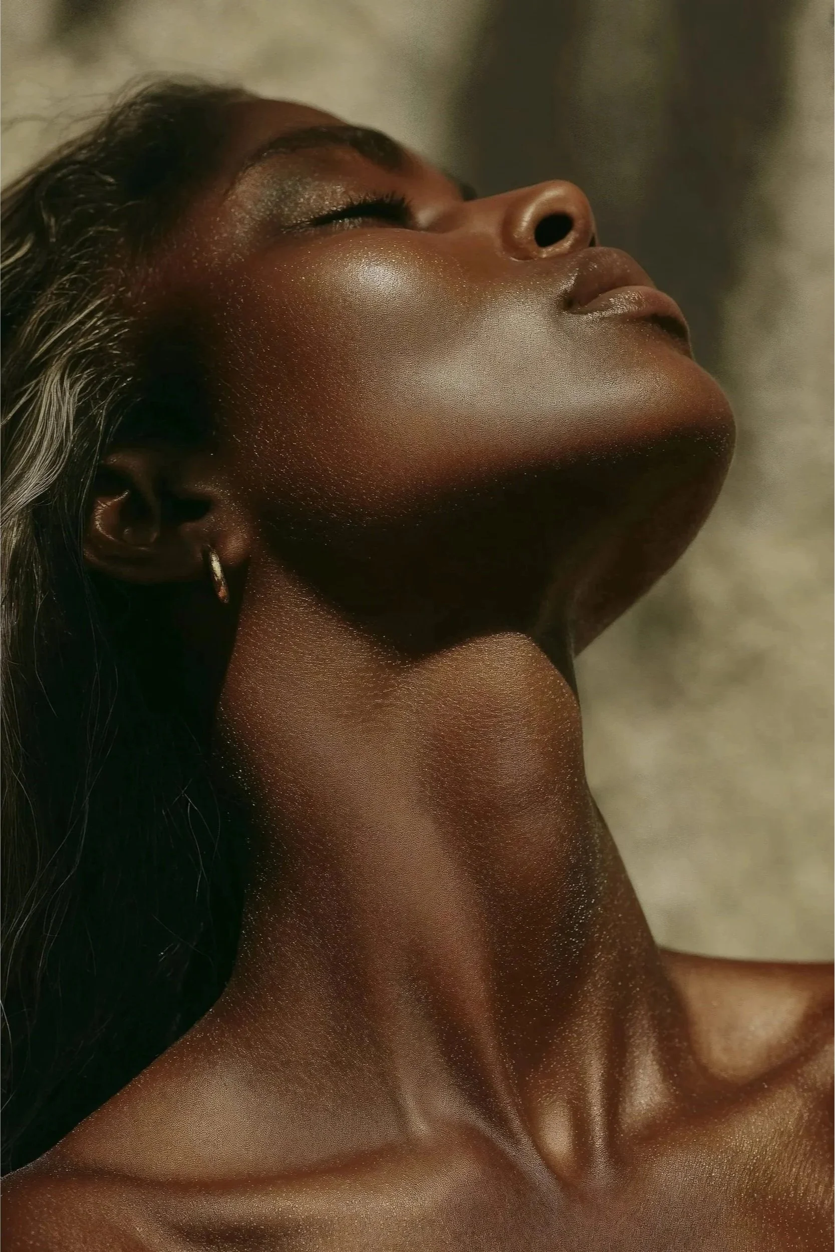Image of woman from head down to shoulders with her eyes closed and head thrown back slightly revealing full neck