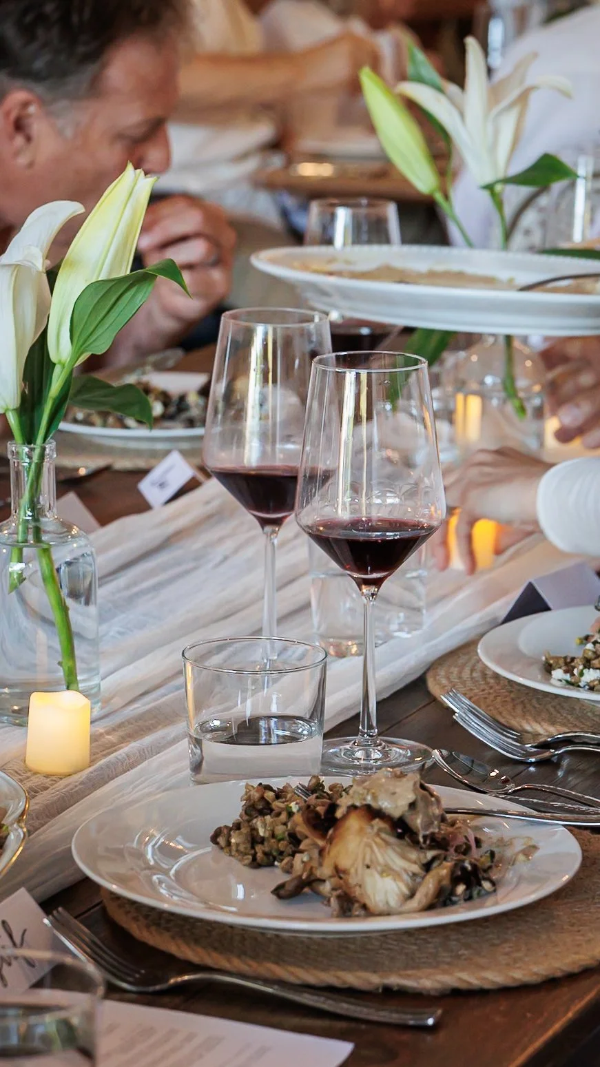 Glasses raised around the dinner table at Farm Blanc et Rouge, capturing a joyful evening of good wine, great food, and even better company