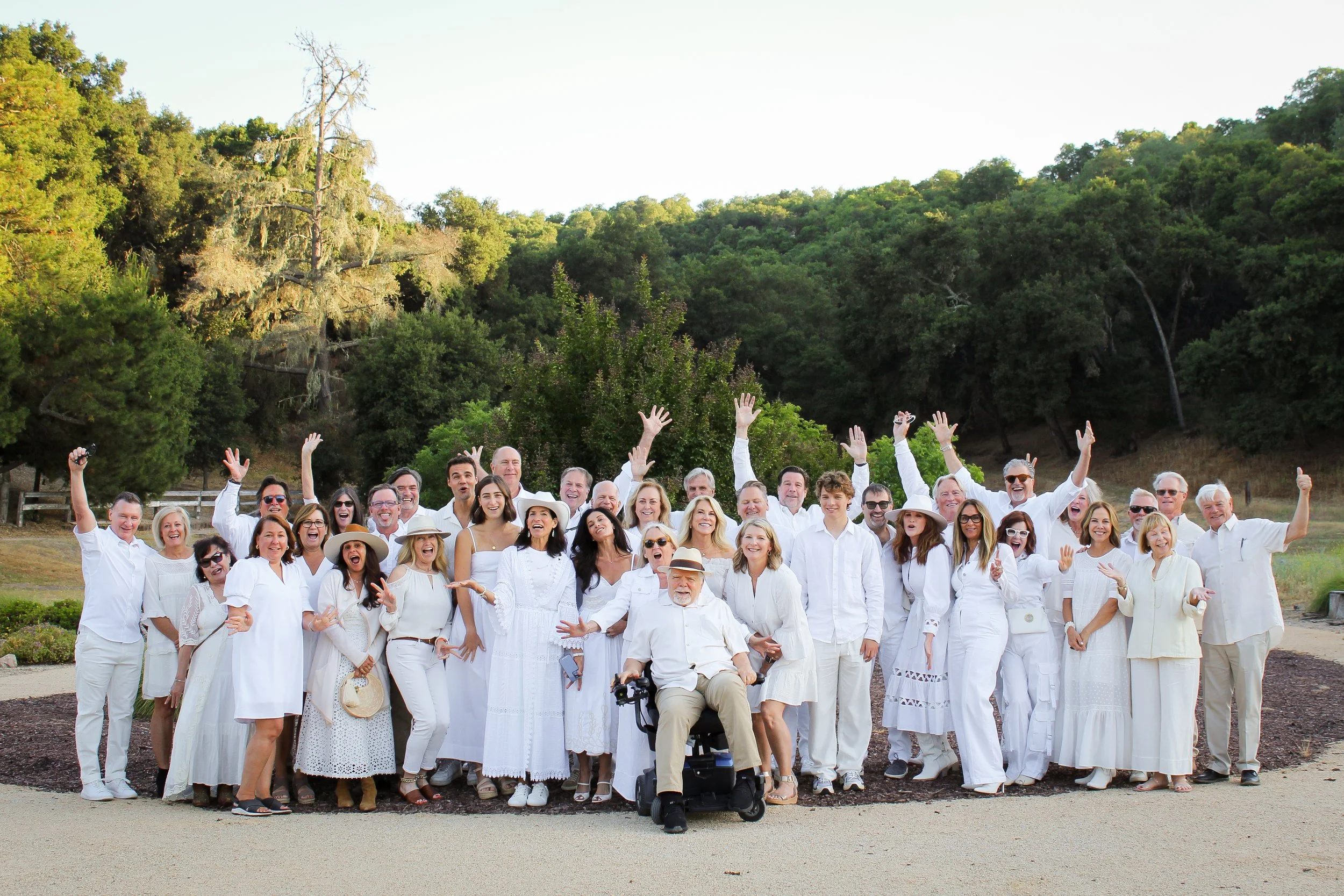Guests enjoying a fun outdoor white party dinner at Farm Blanc et Rouge, with laughter, long tables, and a celebratory wine country atmosphere