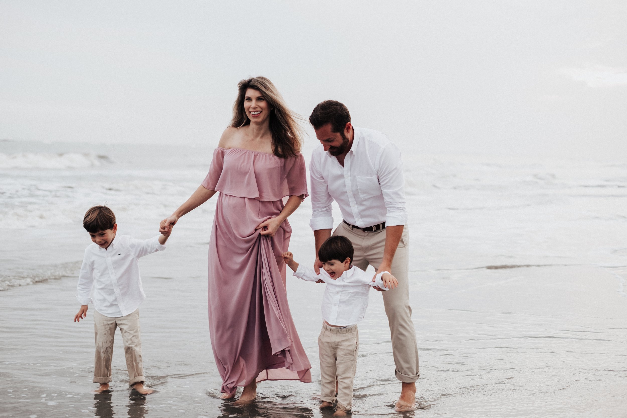 Pregnant mother and family walking on beach - The Koeslings Photography