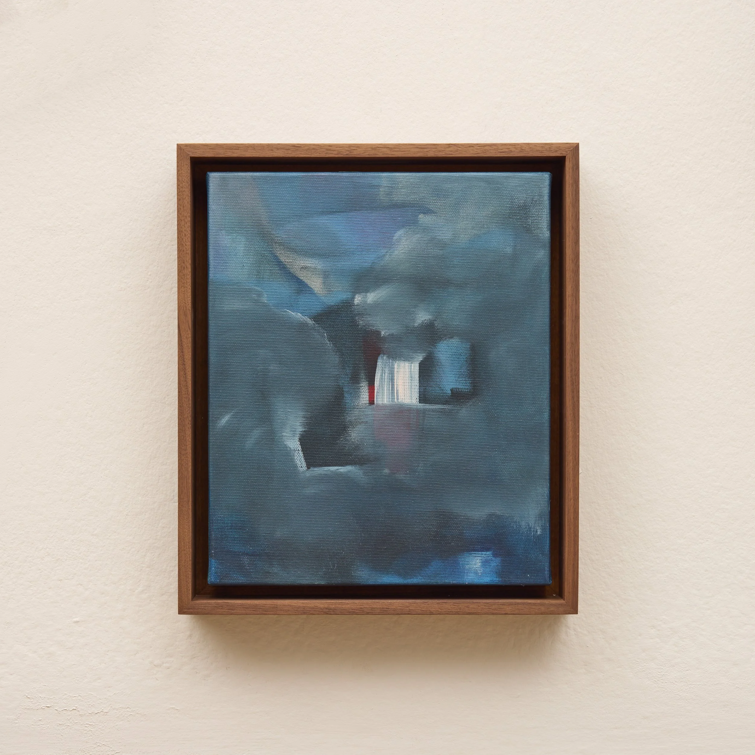 A framed painting with a cloudy sky scene hanging on a textured beige wall.
