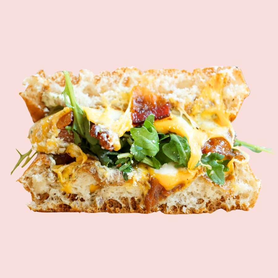 Canadian Quesadilla: pesto cream cheese, three cheeses melted, maple candied bacon, arugula, sandwiched between a waffle