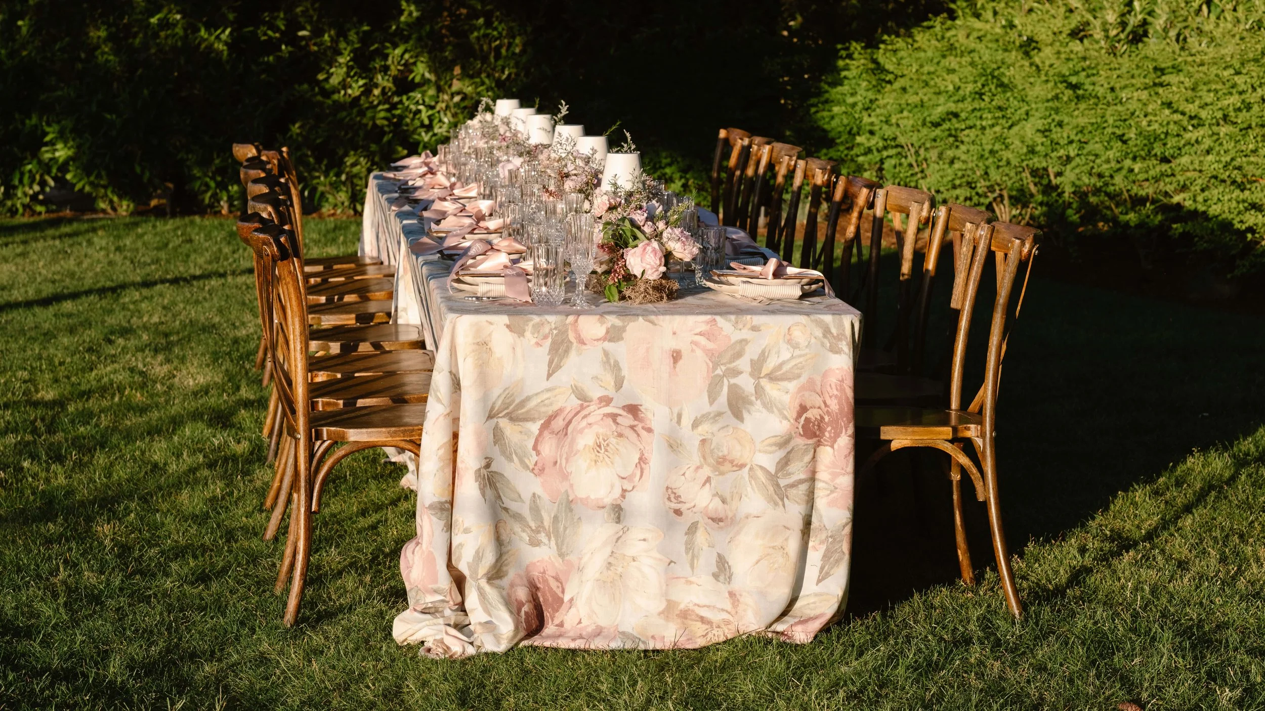 Long table reception setup for a Pacific Northwest micro wedding venue with floral linens and glassware.