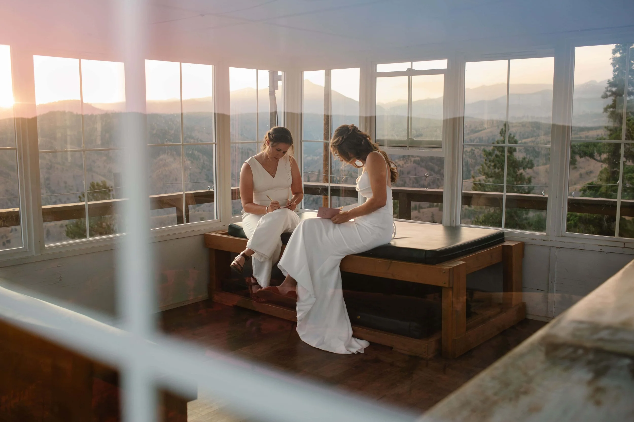 two brides writing vows at sunset in the pacific northwest
