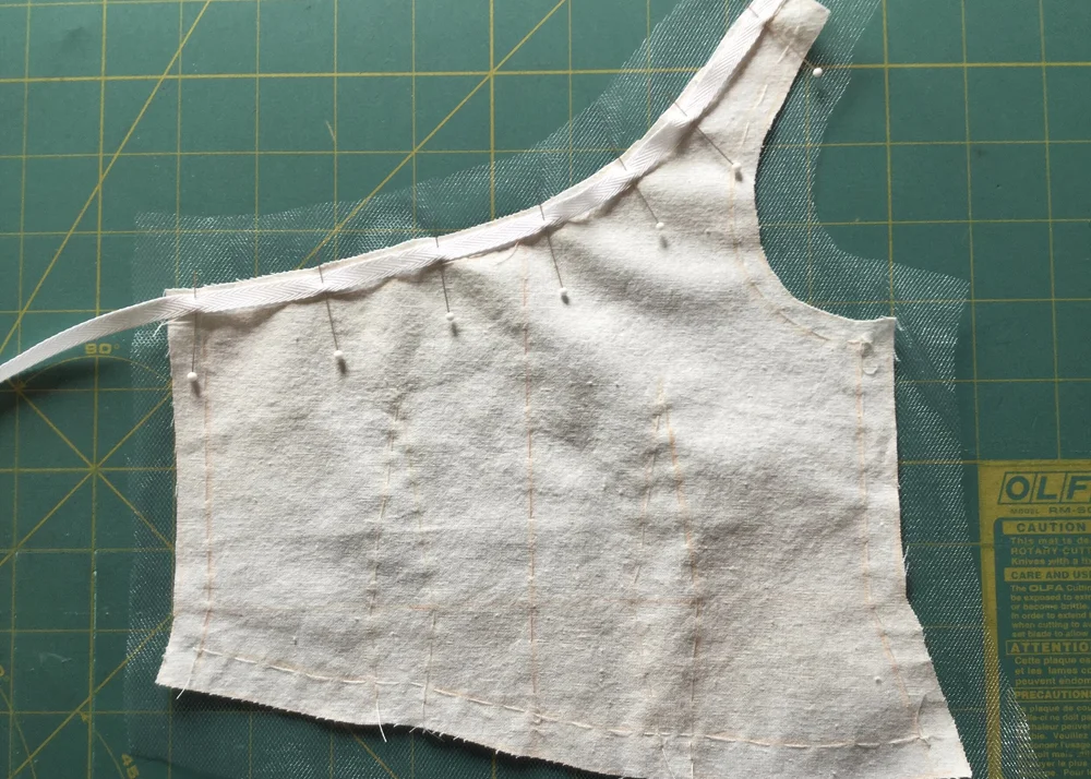 Applying twill tape to stabilize neckline.