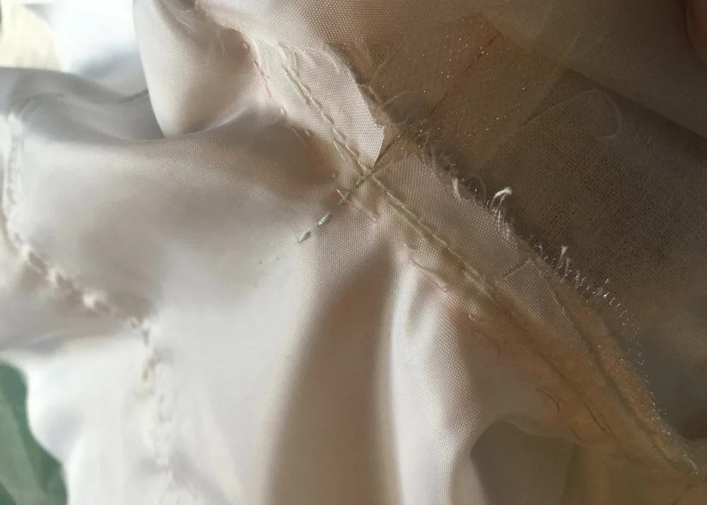 Stitching the skirt lining to the dress.