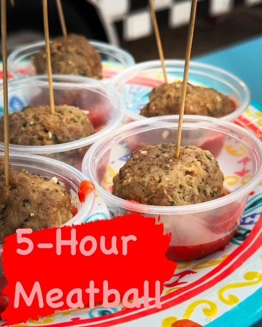 Meatballs in clear plastic cups with toothpicks, on a tray with a colorful design, labeled "5-Hour Meatball".