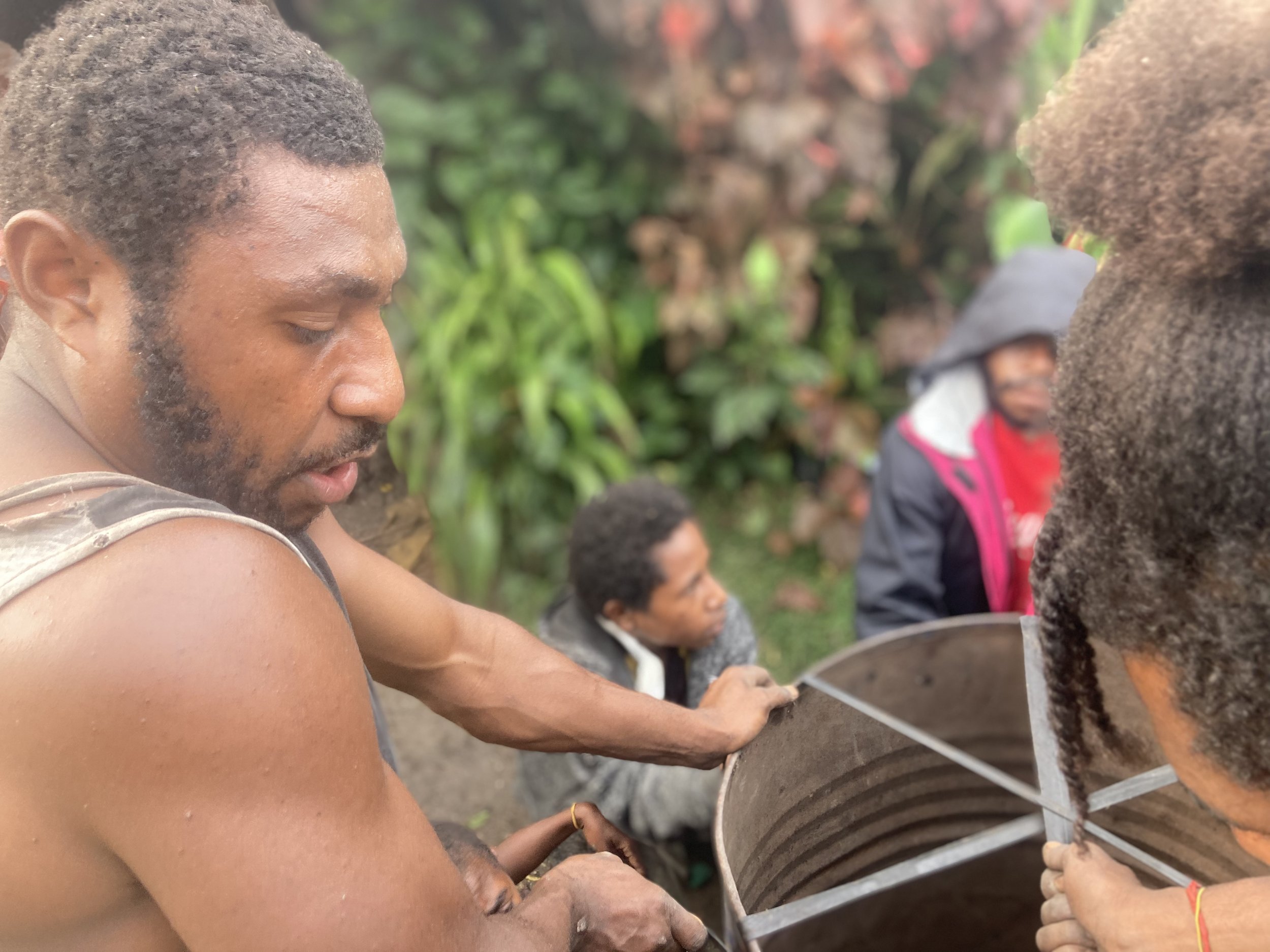 Young men tightening rubber to make a loud drum for the festival