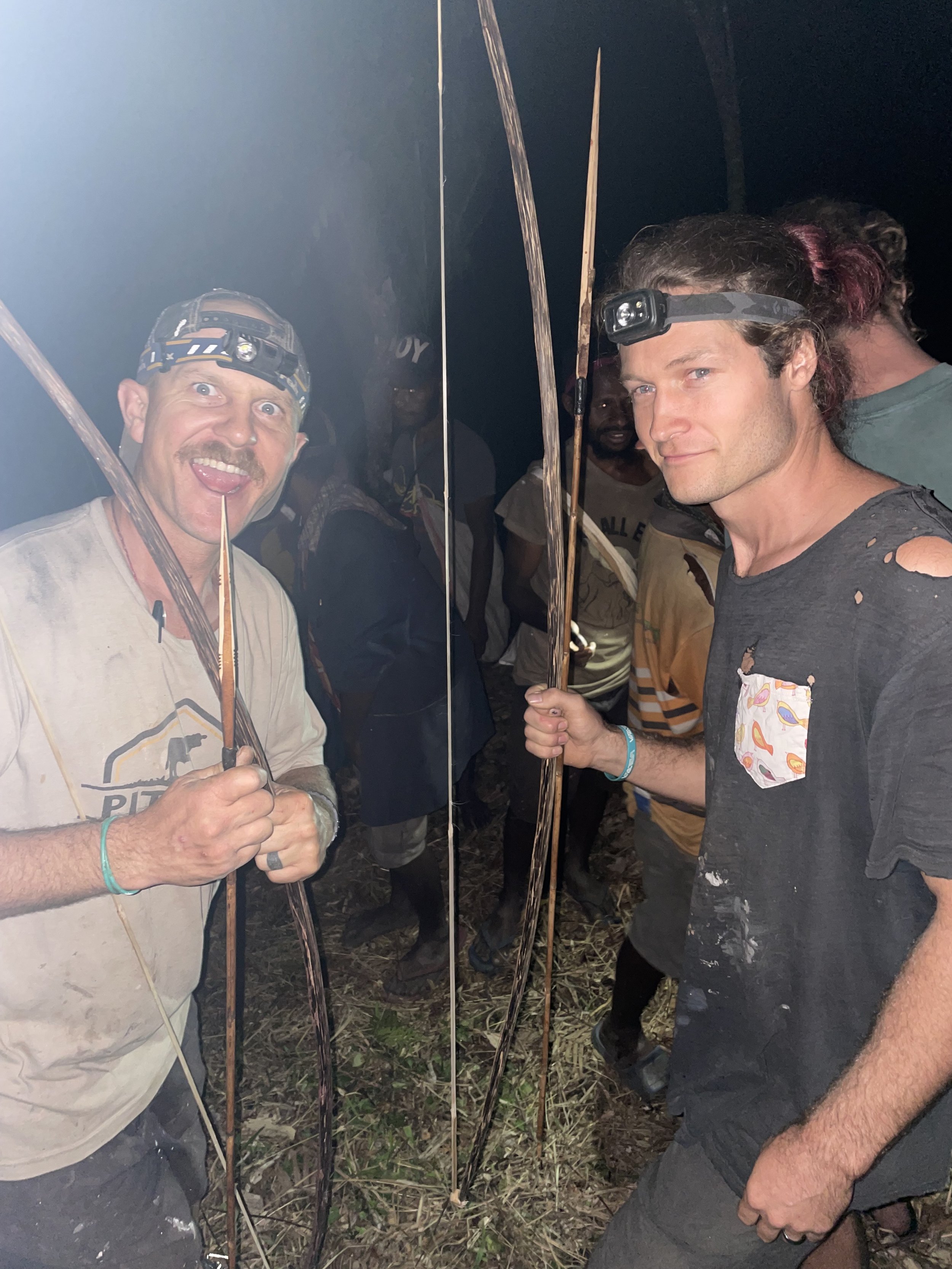 Luke and Chris being given bows and arrows to shoot the pigs for the big party