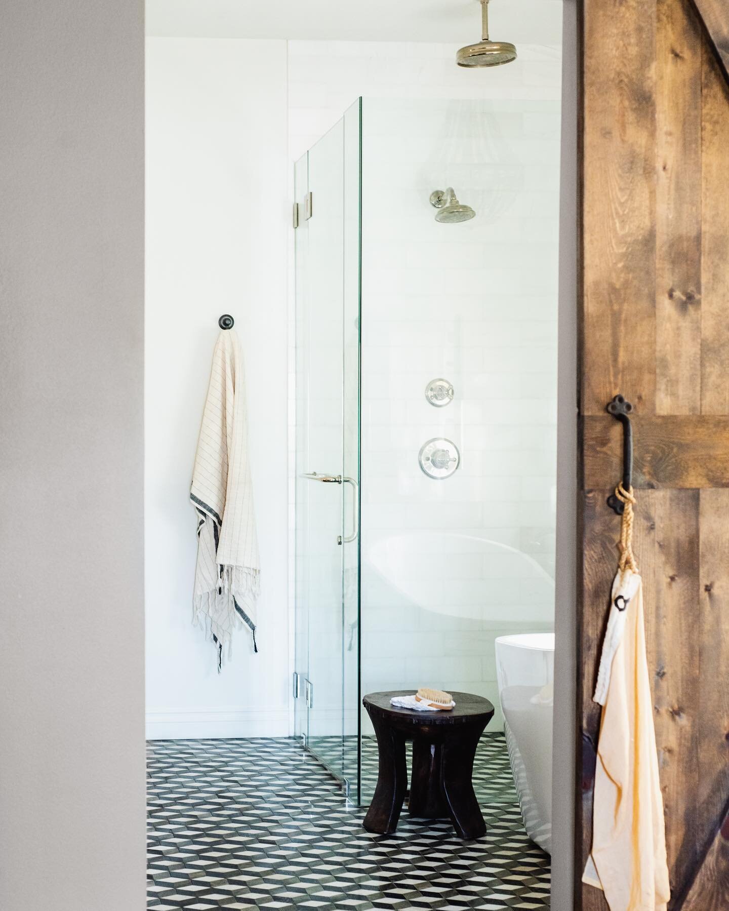 Is your #bathroom door messing with your space planning? Go the #barndoor route! While traditionally considered a #rustic feature, we love to pair it with contemporary elements to create a #juxtaposition of old vs. new. It highlights the beauty in bo