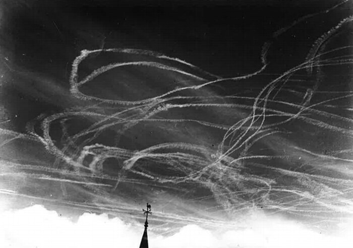 Royal Air Force and Luftwaffe fighters and bombers are knotted in combat high above Maidstone, England in 1940. The condensation vapour trails in the high altitudes trace the battle as it unfolds. Many of the contrails can be seen in pairs as either…