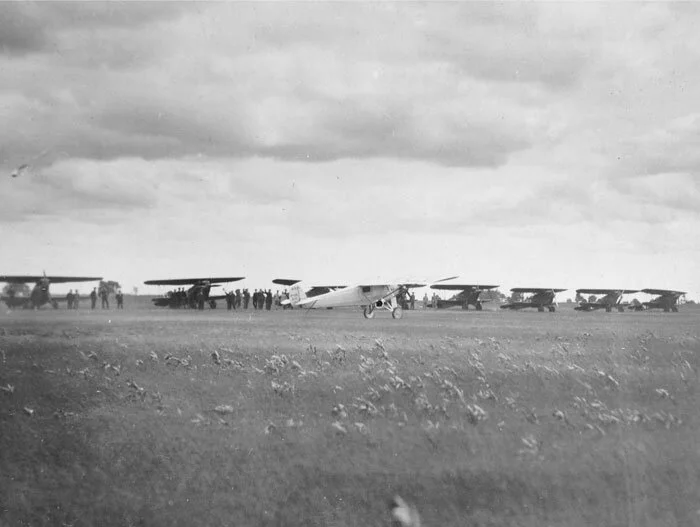 Charles Lindbergh taxies the Spirit of St. Louis along the line of eleven Curtiss P-1 fighters of the United States Army. I believe, given the direction he is travelling and the lack of accompanying runners or large crowds, that this is a photo of his departure—either to drop flowers over Johnson’s funeral train on 3 July or his ultimate departure to Teterboro Airport in New Jersey. On this final flight, Lindbergh circled overhead Ottawa for 35 minutes. We can see men discreetly waving to Lindbergh as he taxies by—possibly the pilots of the Curtiss P-1 Hawks. Photo via Canada Aviation and Space Museum