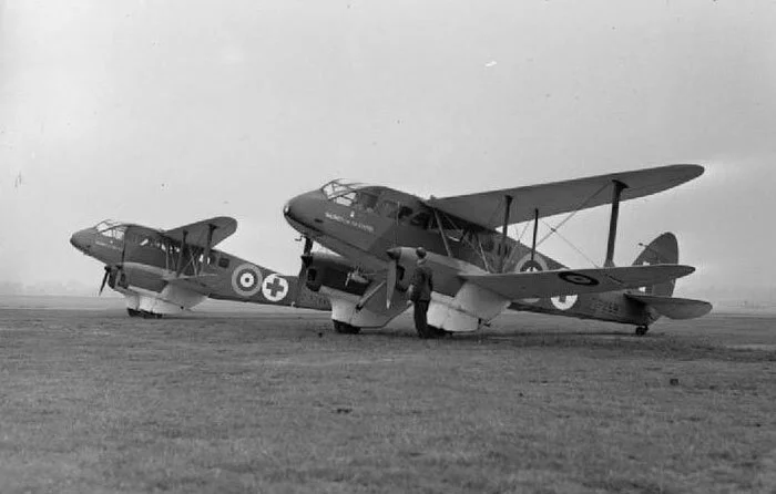 On the ground at RAF Hendon, DH.89s Women of the Empire and Women of Britain present themselves for photographers. The DH.89 was known as the Rapide in civilian service and Dominie in the Royal Air Force. The RAF’s Hawker Siddeley HS125 jet transport of today is also called the Dominie. The word Dominie is a Scottish term for a schoolmaster. Photo: Imperial War Museum