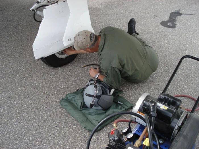 After we rolled the Trojan out to the ramp, Bruce checked pressures (60 psi) in all three tires. Had we been recovering on a carrier, it would have been substantially more. Photo: Dave O'Malley
